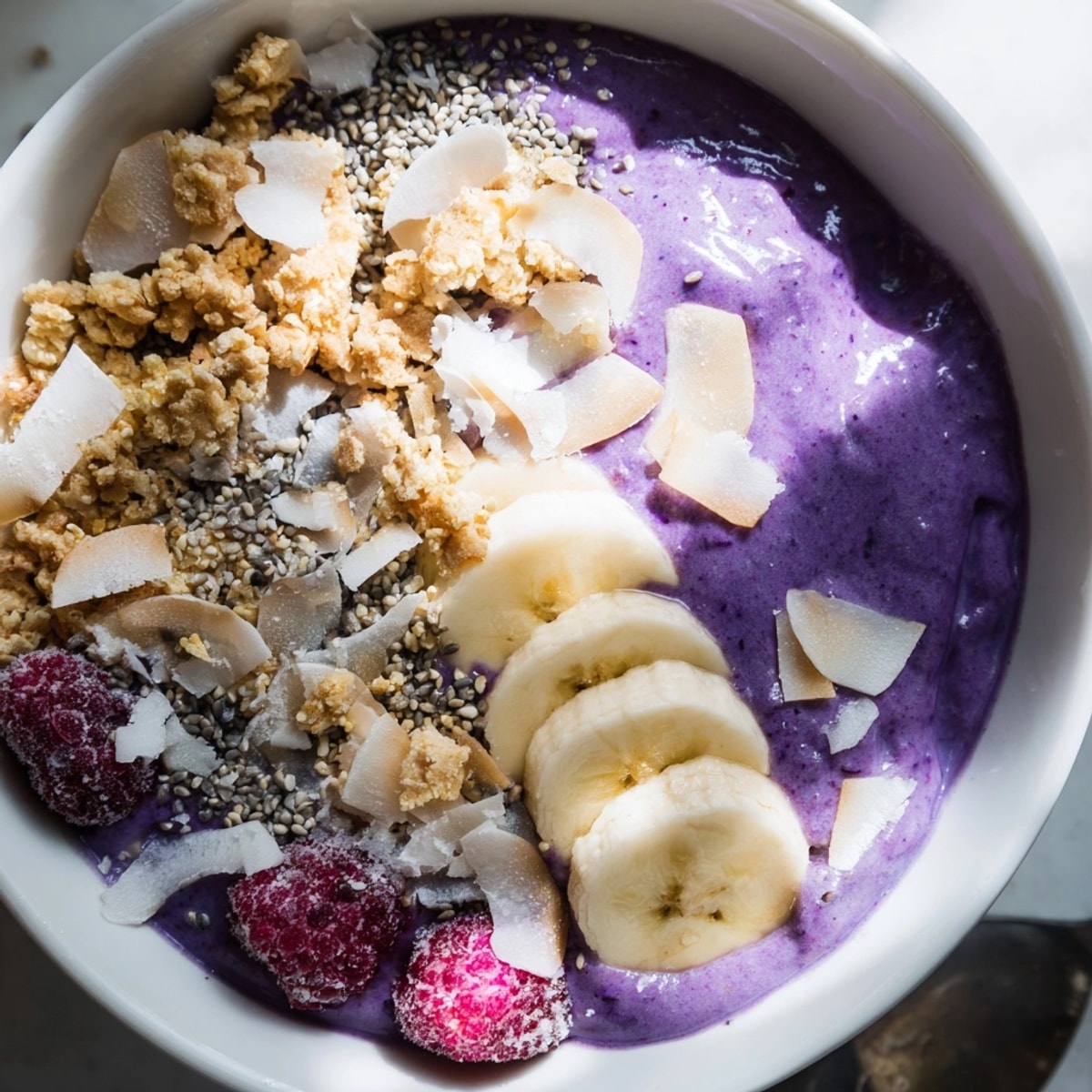 Un smoothie bowl décadent à l'Ube, Banane et Coco, magnifiquement présenté pour le petit déjeuner.