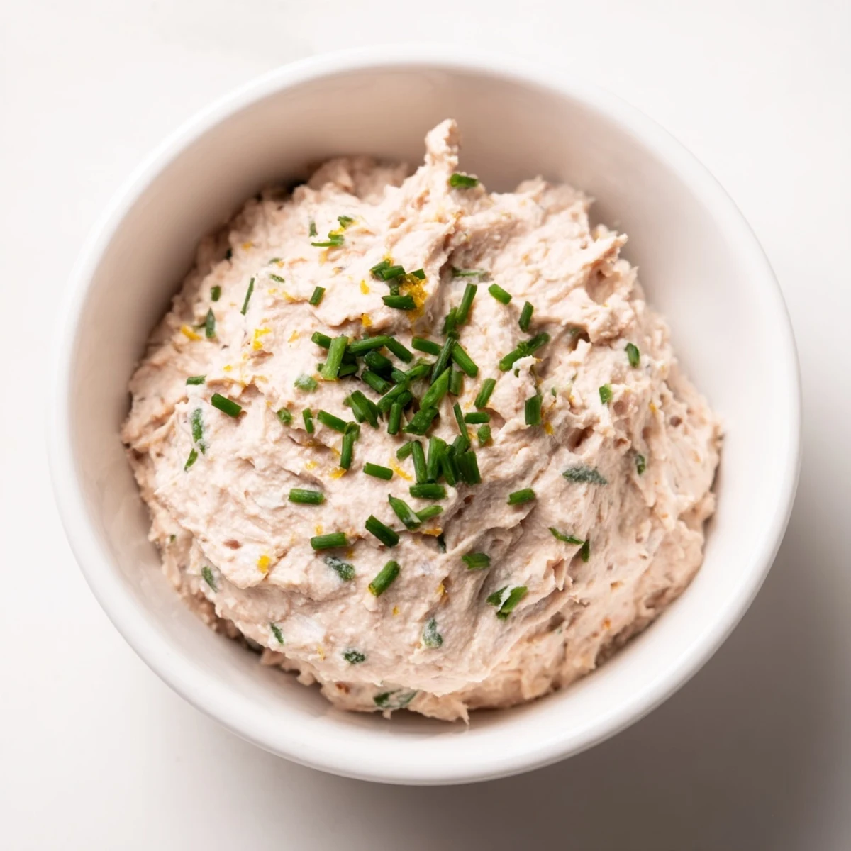 Pâté de thon crémeux servi sur des tranches de baguette croustillante.