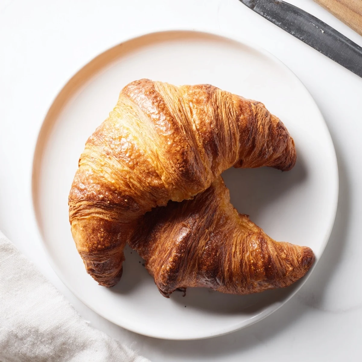 Minces croissants français, garnis de chocolat ou de confiture, idéaux pour un brunch.  