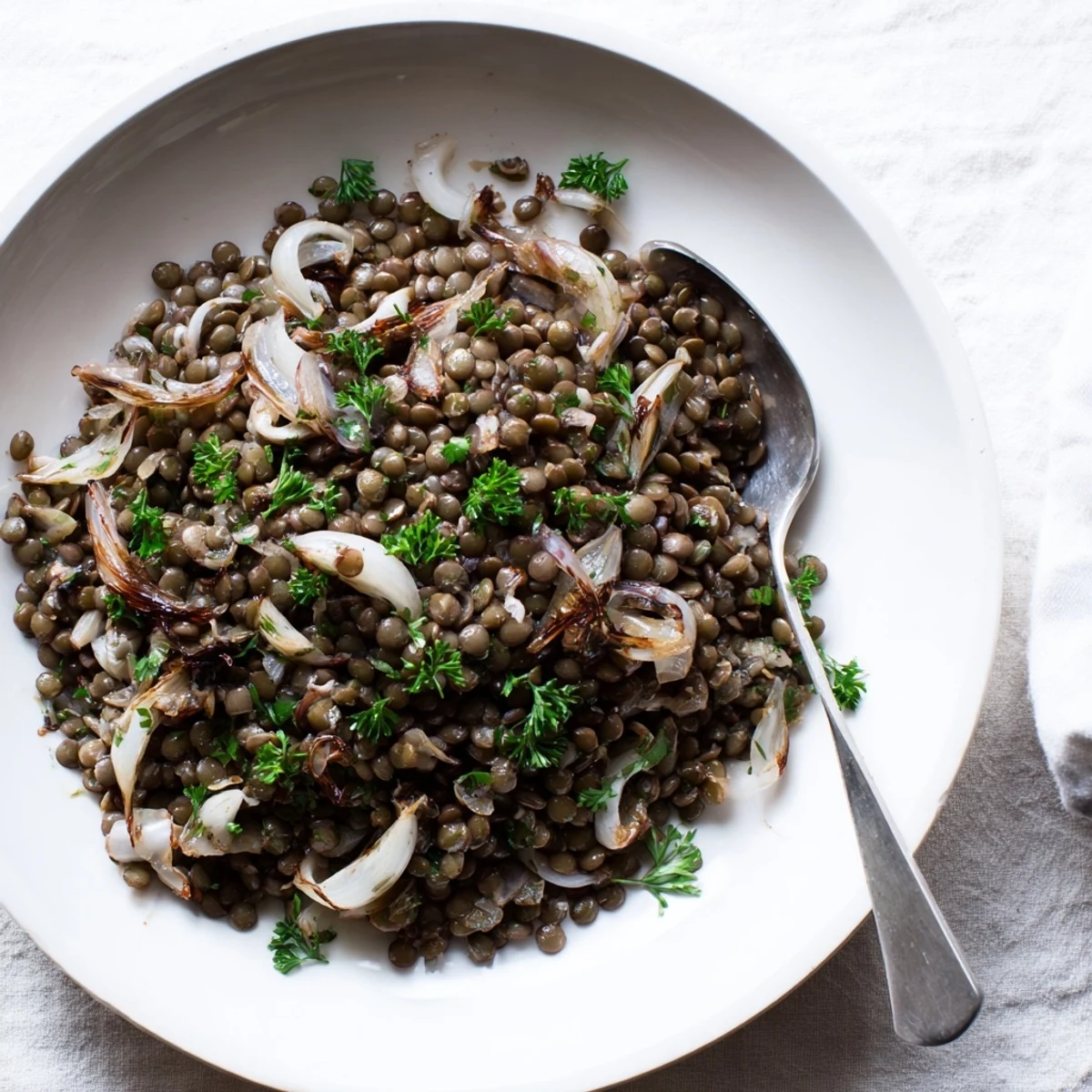 Enjoy a healthy serving of fresh warm green lentil salad, perfect for a light lunch.