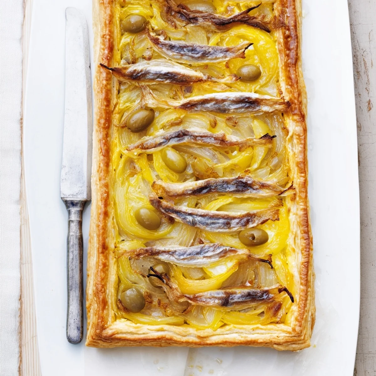 Warm, flaky Classic Onion Pissaladière Tart, a savory appetizer brimming with caramelized onions.