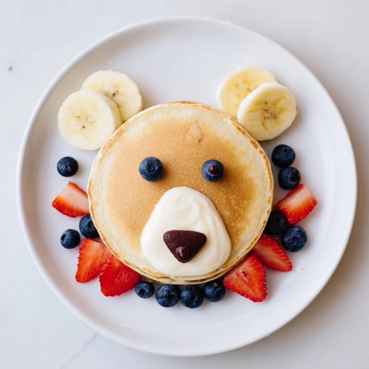 A fluffy stack of Polar Bear Pancakes, adorable faces made with yogurt and chocolate chips.