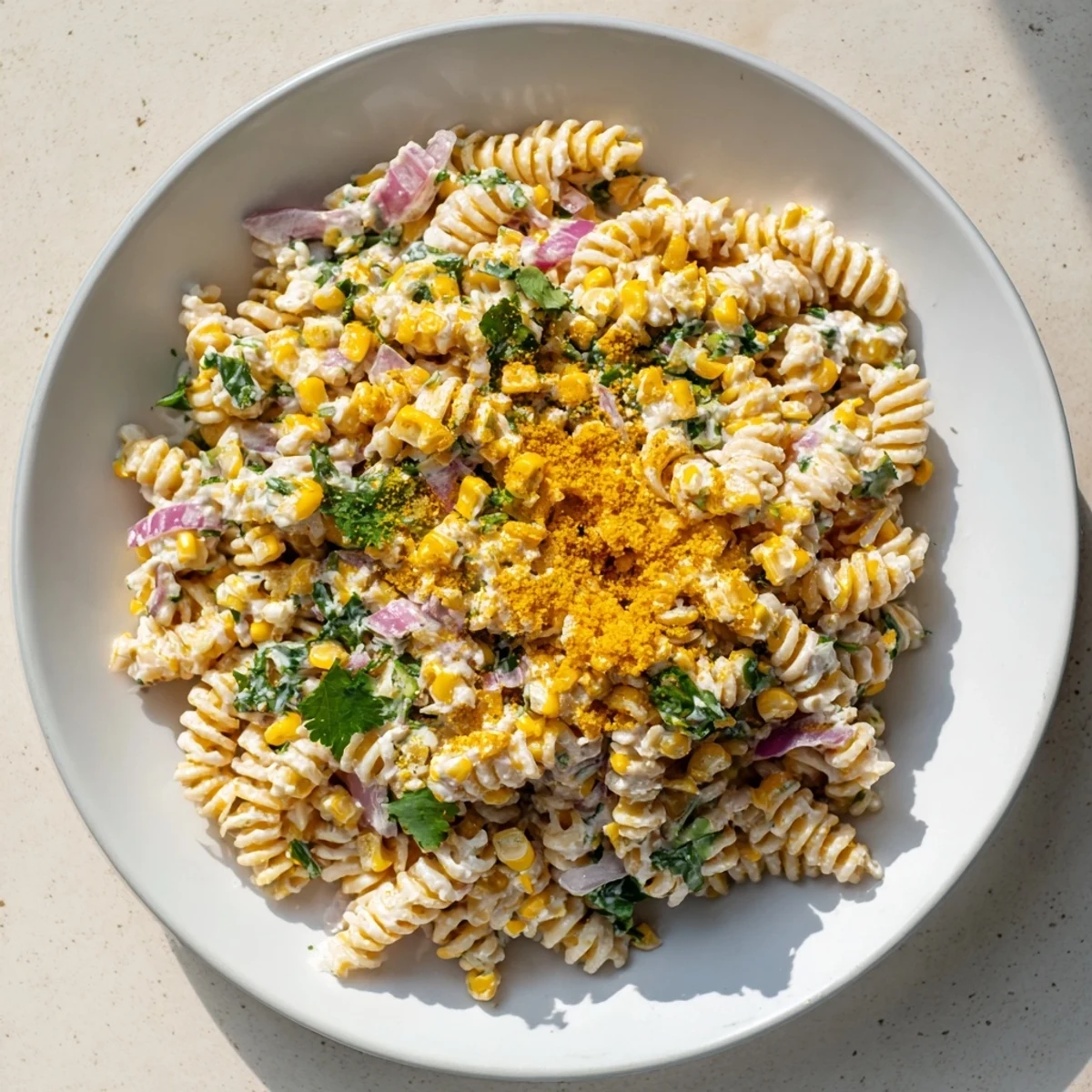 A bowl of Creamy Street Corn Pasta Salad, perfectly showcasing charred corn and fresh herbs.