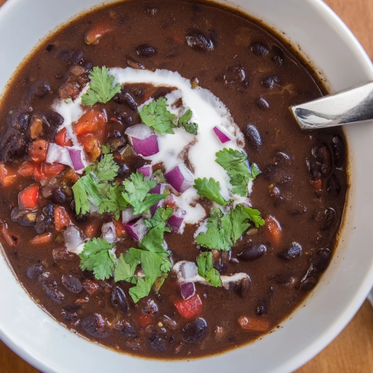 Soupe réconfortante aux haricots noirs, aux notes de cumin et paprika, idéale avec un filet de citron vert.
