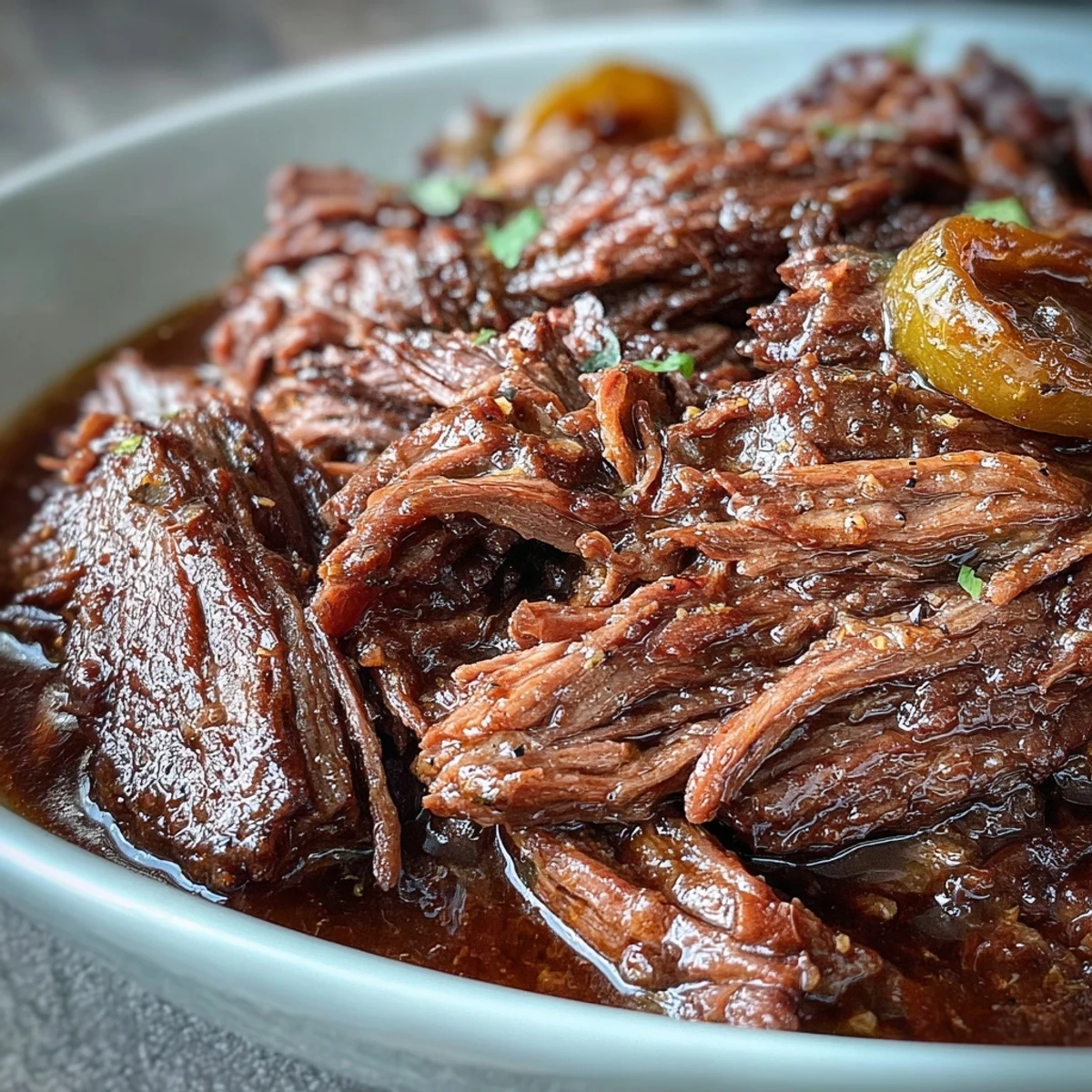 Tender Slow Cooker Mississippi-Style Ranch Beef shredded in its rich juices, ideal for piling onto toasted buns for a hearty American meal.