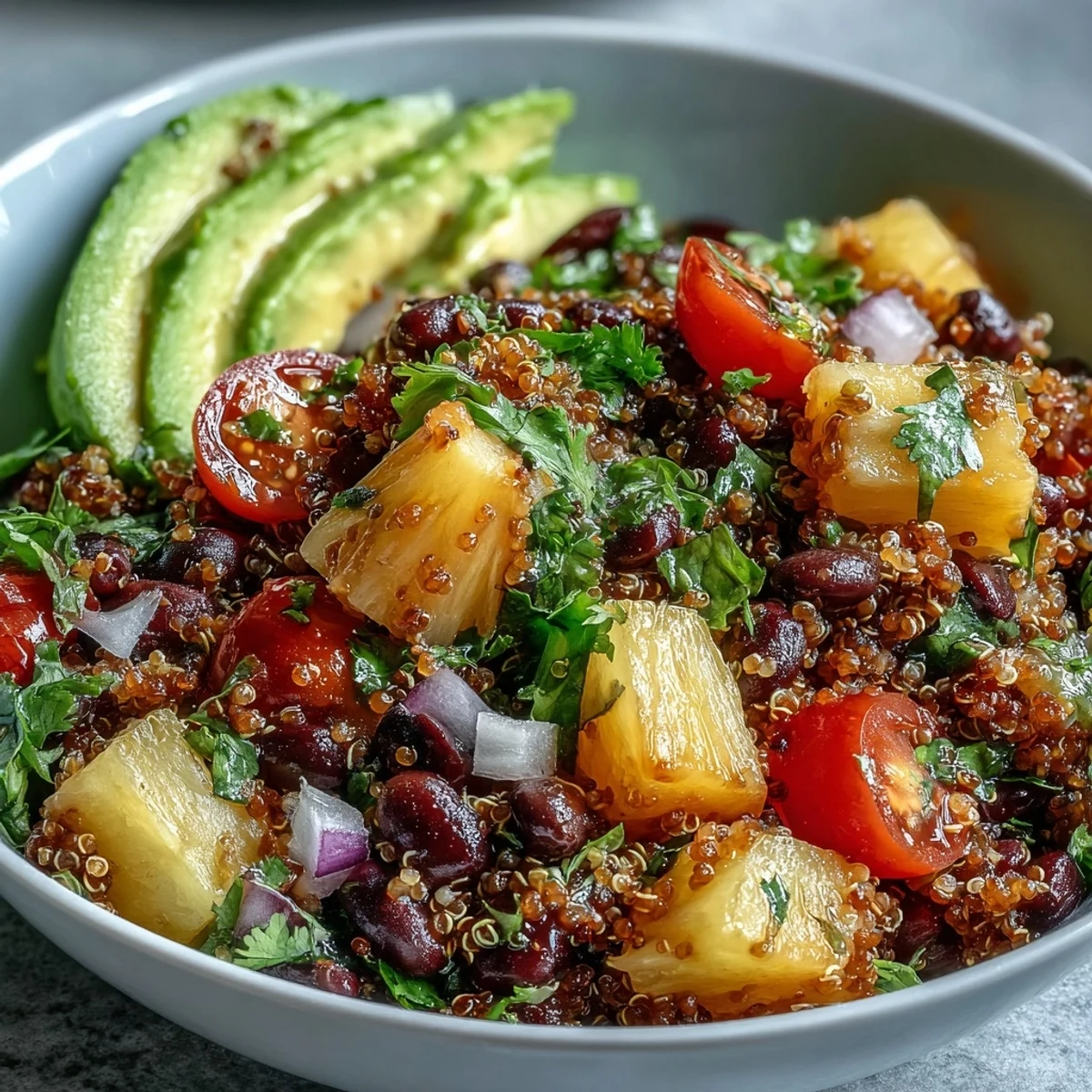 Tropical Quinoa Salad with Pineapple and Black Beans près d'une lime pressée, feuilles de coriandre et vinaigrette à l'huile d'olive. (13 mots)