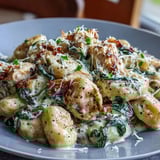 Gnocchi et poulet dorés nappés de sauce à la parmesan et d'épinards frais fumants.