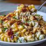 White bowl of Creamy Jalapeño Popper Chicken Pasta topped with fresh jalapeños and chives