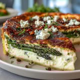 Tarte printanière aux asperges et à la pâte feuilletée, dorée et croustillante, garnie de pointes d'asperges tendres et de fromage fondant.