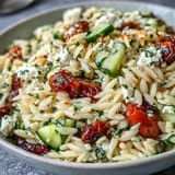 Orzo mediteranéen coloré avec tomate, feta crémeuse et vinaigrette au citron.