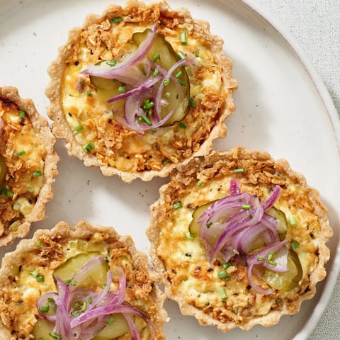 Tartlets de Pickle de Gallois, garnies de cheddar et d'oignons marinés croustillants.  