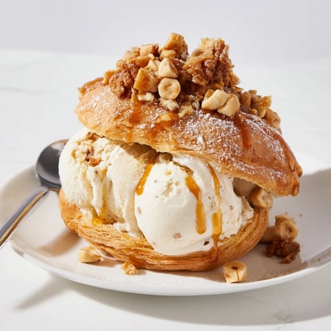 Sundae Paris-Brest au soda au gingembre, garni de noisettes caramélisées et de sucre glace.  
