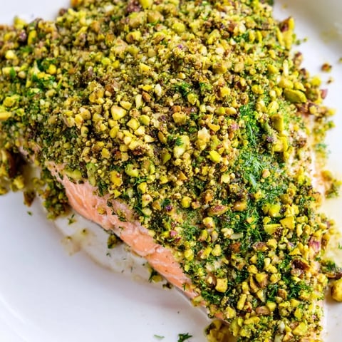 Ces filets de saumon confit au four, nappés d’une croûte crémeuse de tahini, pistaches et herbes fraîches, appétissants.