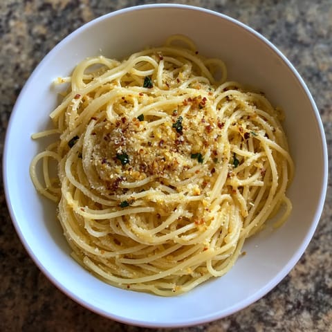 Une assiette de spaghetti avec des herbes et des légumes.