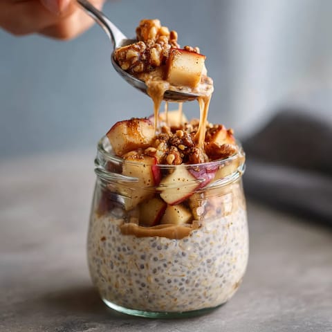 Une personne tire une cuillère remplie de nourriture dans un vase rempli de fruits.