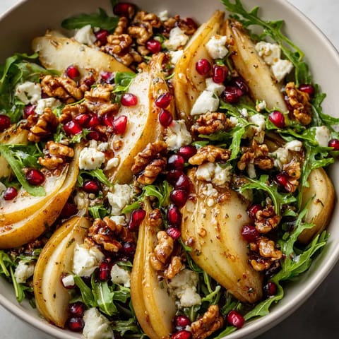 Une salade de fruits et légumes, avec des pommes, des poivrons, des raisins, des noix et des épinards.