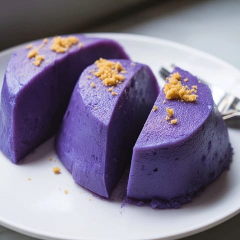Un appétissant Ube Halaya dans un moule, prêt à être servi avec de la noix de coco grillée.
