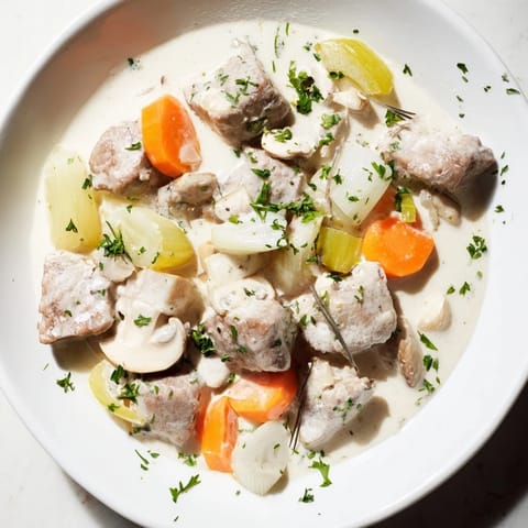 Aromatic Blanquette de Veau simmering, featuring veal, vegetables, and fragrant kaffir leaves in broth.