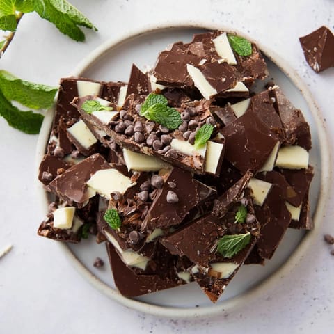 Melted chocolate and crushed peppermint create beautiful, shareable Peppermint Bark Shards on a wooden board.