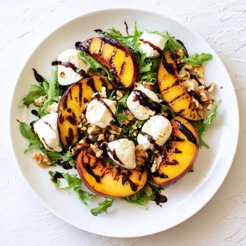 Freshly grilled peach salad with creamy burrata, perfect for a light vegetarian lunch.