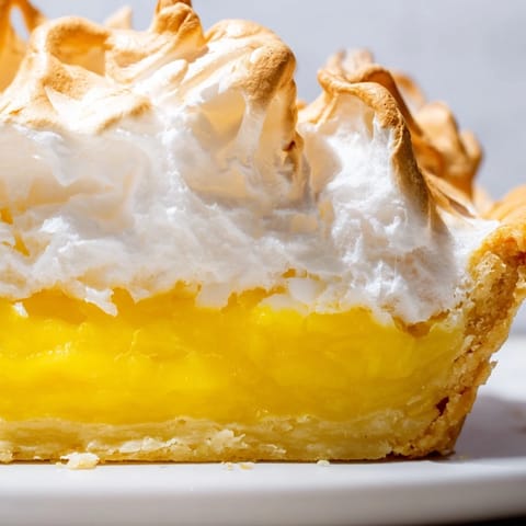 Serving of Lemon Meringue Pie with a sweet, fluffy meringue topping and a tart lemon base.