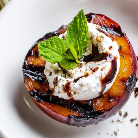 Golden-brown grilled plums garnished with fresh mint, ready to serve as an elegant appetizer or dessert.