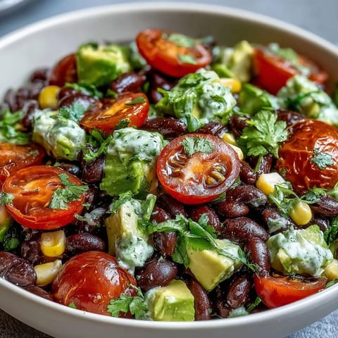 Assiette colorée de haricots noirs, maïs sucré et tomates juteuses, nappée d'une vinaigrette au citron vert.