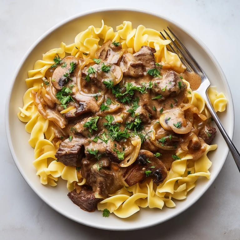 Une assiette de spaghetti bolognaise avec des champignons et des herbes.