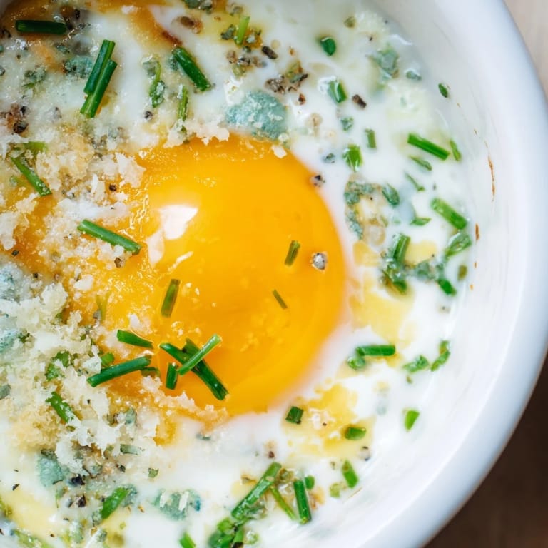 Oeufs shirred élégamment cuits, servis avec une touche de fromage fondant.