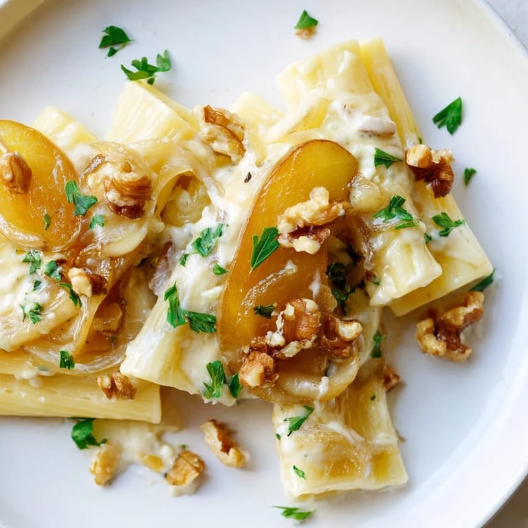 Beautifully plated Rococo Pasta features a swirl of pasta, creamy sauce, and sweet pears.