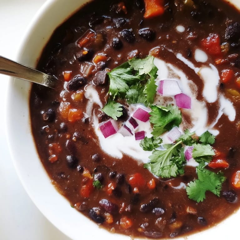 Haricots noirs mijotés avec épices fumées, servis avec une garniture de coriandre et d'avocat.
