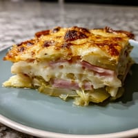 Une pizza en forme de cake, avec des légumes et du fromage, sur un plateau.